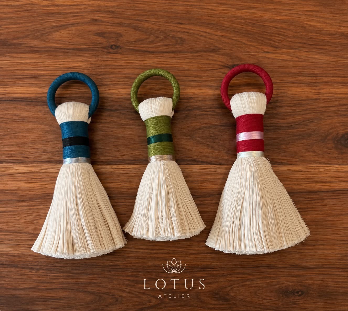 Borlas con aro forrado en azul, verde y rojo sobre una mesa de madera